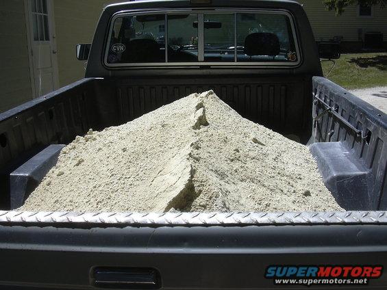 1992 Ford F-250 pickup truck bed loaded with sand, rear view