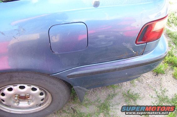 Blue car rear quarter panel with fuel door and taillight