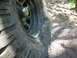 1996 Jeep Cherokee - Off-road tire wedged against a rock on a dirt trail.