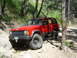 1996 Jeep Cherokee - Red 1996 Jeep Cherokee navigating a challenging rocky off-road course.