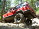 1996 Jeep Cherokee - This red Jeep Cherokee is navigating a rocky off-road trail.