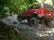 1996 Jeep Cherokee - A red 1996 Jeep Cherokee tackles a challenging rocky trail, with another vehicle visible in the background.