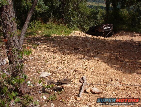18heep.jpg Trash on the trail!  Our entrance to the Rubicon was blocked by this abandoned Heep, whose LHF steering knuckle was no longer attached to the axle housing.  We did him the favor of pulling it back up to level ground.  Unfortunately, his LHR tire came off the rim in the process, and the LHF tie rod end separated.  Sorry, but I doubt he could have gotten it out of there in any better condition.