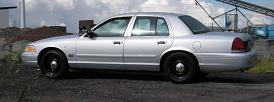 1998 Ford Crown Victoria side view, silver paint, black wheels