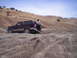 1989 Ford Bronco - A 1989 Ford Bronco navigates a steep, gravelly incline under a clear blue sky.