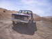 1989 Ford Bronco - This Ford F-150 pickup truck is parked on a gravelly incline under a clear blue sky.