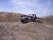 1989 Ford Bronco - A man drives a two-tone Ford pickup truck off-road on a sunny day.