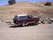 1989 Ford Bronco - This Ford Bronco is parked on a dirt road with a dry, hilly landscape behind it.