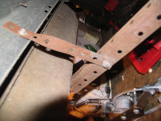 Rusty metal running board mounting brackets inside a vehicle