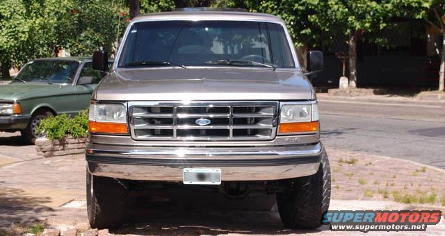 Silver Ford Bronco front view, chrome grille, orange turn signals, aftermarket wheels