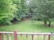 1989 Ford F-250 - A view of a backyard with lush green grass and mature trees, seen from a deck.