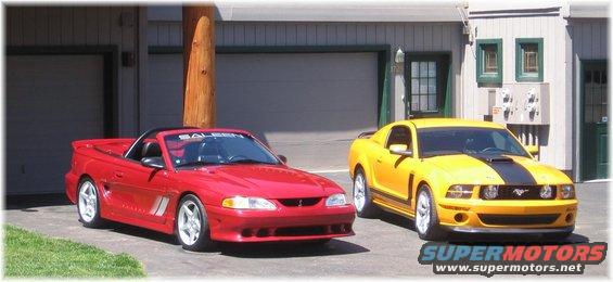 Red convertible Mustang and yellow coupe Mustang parked in front of garages. Red car has 'SALEEN' on windshield banner