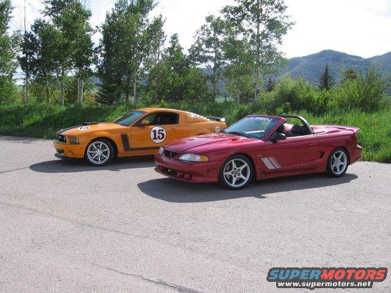 Orange Mustang with racing stripes and number 15, next to a red convertible Mustang