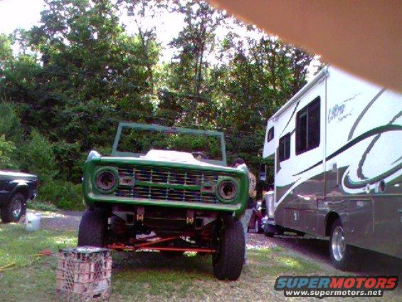 1974 Ford Bronco, green, no top, parked next to an RV