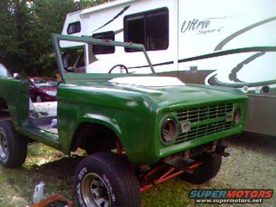 Green 1974 Ford Bronco with missing windshield and doors, front view
