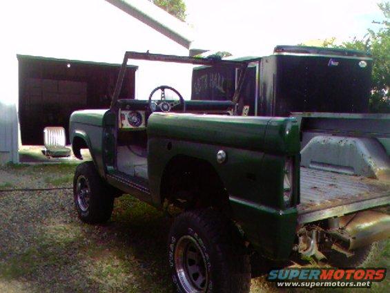 Green 1974 Ford Bronco with doors removed, viewed from the 3/4 front