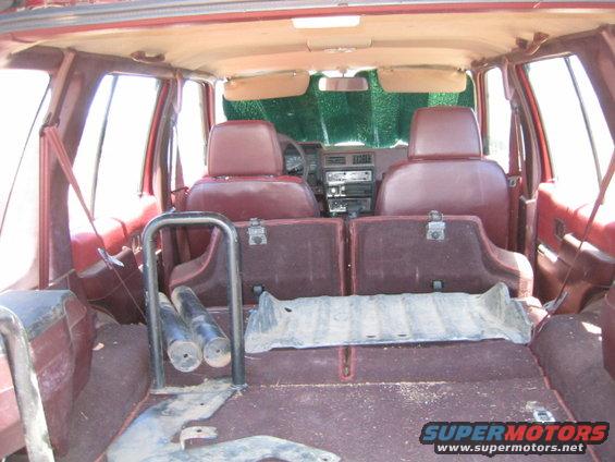 Interior view of a red SUV, showing the back seats, cargo area, and dashboard