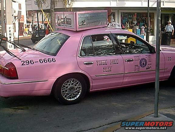Pink 2001 Ford Crown Victoria taxi with "THINK PINK TAXI" text and license plate 296-6666