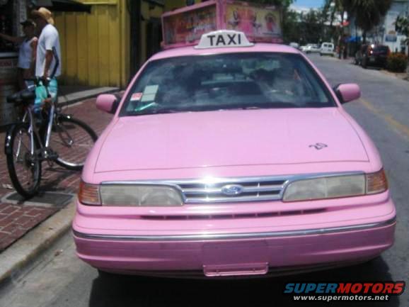 Pink taxi with TAXI sign on roof