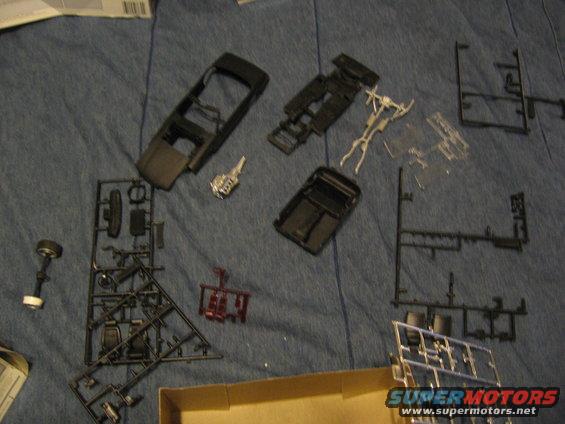 Plastic model kit parts laid out on a blue fabric surface