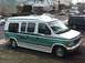 1992 Ford E150 - This 1992 Ford E150 van is seen from the front passenger side, parked on a street with grass in the foreground.