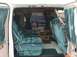 1992 Ford E150 - Plush teal interior of a van, with a glimpse of another vehicle through the rear window.