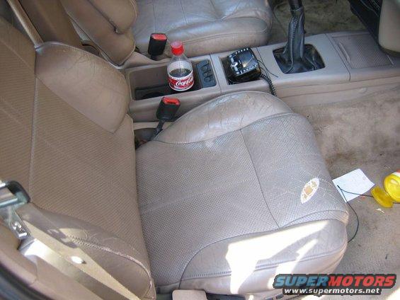 car interior with tan leather seats, cup holder with Coca-Cola, and CB radio