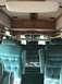 1992 Ford E150 - The interior of the van features plush teal seats and wood paneling, with curtains visible in the background.