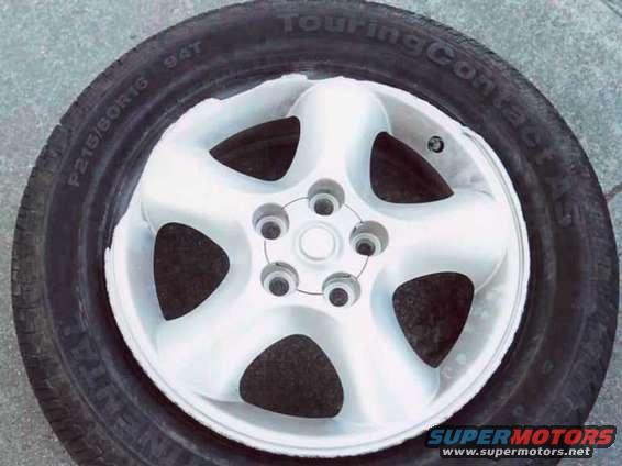 The rim after the 2 impacts, dragging in the dirt, and pushing into a parking lot.  The black tire easily defines where the chunks of the rim were gouged out.
