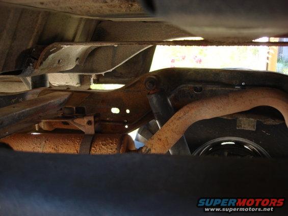 new-lines4.jpg it is hard to see the main line but it runs inside the frame rail behind the shock and pokes out a hole in the frame and connects to the front hard line with a slice of fuel line.