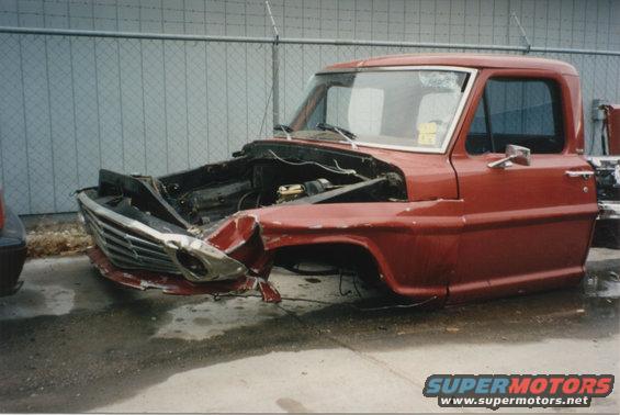 1967 Ford F-100 cab with heavily damaged front end, missing hood and fenders