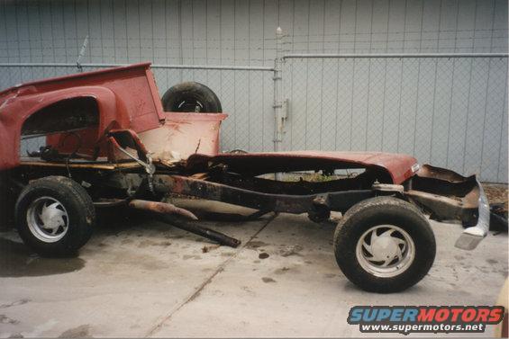 1967 Ford F-100 chassis with red cab and bed, heavily damaged