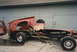 1967 Ford F-100 - This heavily damaged pickup truck chassis sits in a yard, stripped of its cab and bed.