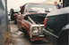 1967 Ford F-100 - A damaged 1967 Ford F-100 pickup truck sits in a yard, its hood open and windshield cracked.