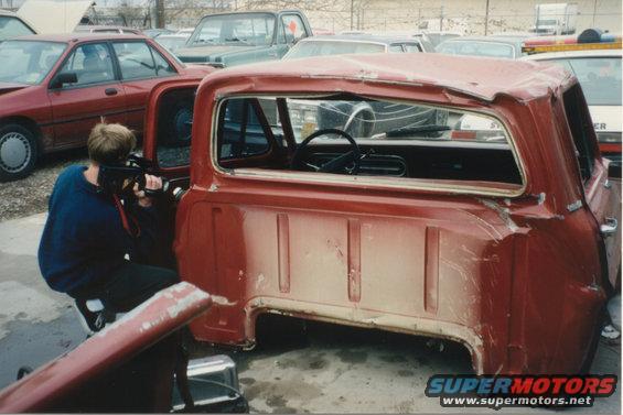 Red 1967 Ford F-100 pickup truck cab, side view, showing damage