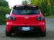 2007 Mazda 3 - Rear view of a red 2007 Mazda 3 hatchback parked on a gravel road.