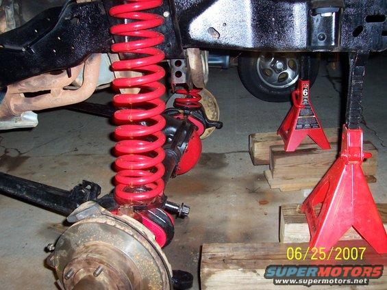 Red coil springs and suspension parts on jack stands