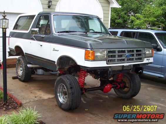 Lifted white and gray Ford Bronco with red suspension, front 3/4 view. Date stamp 06/25/2007