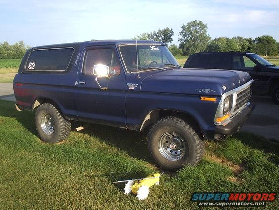 Blue 1978 Ford Bronco parked on grass with another vehicle behind it