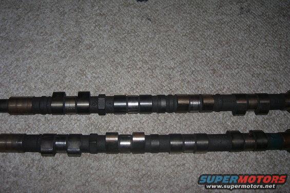 Two camshafts on a carpeted surface