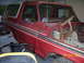 1979 Ford Bronco - This red 1979 Ford Bronco is shown in a garage with its hood removed, revealing its engine bay.