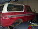 1979 Ford Bronco - This red SUV, likely a 1978 model, is shown from the side in a garage with its rear suspension exposed.
