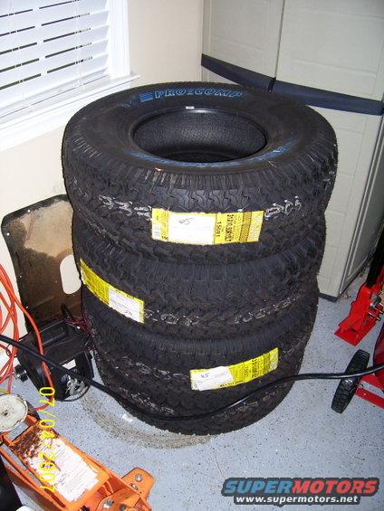Stack of four Pro-Comp tires with yellow labels