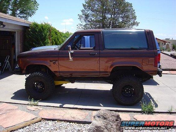1986 Ford Bronco II, lifted with large tires, parked in a driveway