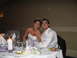 1988 Ford Bronco - A bride and groom smile for a photo at their wedding reception, seated at a decorated table.