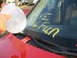 1988 Ford Bronco - A car windshield has yellow writing and a hand holding a balloon.