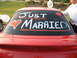 1988 Ford Bronco - A red car's rear window is decorated with "Just Married!" and hearts for a wedding celebration.
