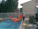 2003 Yamaha RAPTOR 80 - Children enjoy a summer day playing on an inflatable toy in a swimming pool.