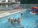 2003 Yamaha RAPTOR 80 - Kids enjoy a sunny day swimming in a backyard pool, with a canal and boats visible in the distance.