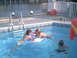 2003 Yamaha RAPTOR 80 - A group of children enjoy a sunny day swimming in a pool next to a body of water.